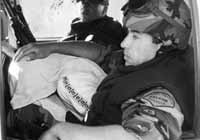 Uno de los chicos es trasladado por la polic&iacute;a con la cabeza cubierta.
