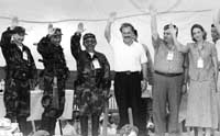 Los representantes de las FARC y el presidente Andr&eacute;s Pastrana (en el centro) saludan y sonr&iacute;en.