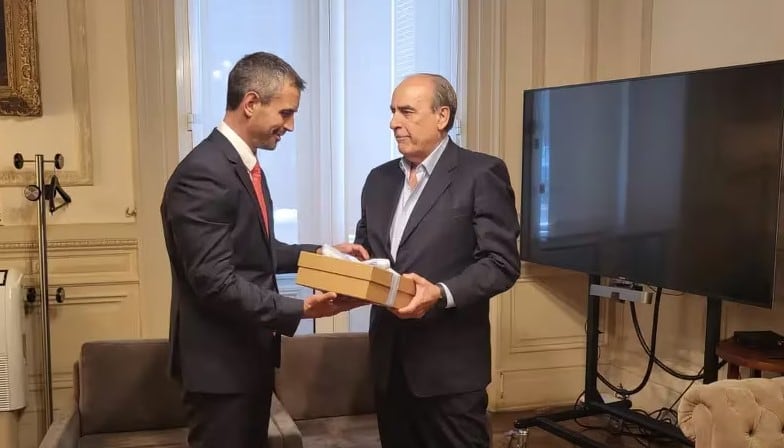 El ministro del Interior, Guillermo Francos (der.), le entrega al titular de la Cámara de Diputados, Martín Menem, el paquete con más de 300 hojas denominado "Ley de Bases y Puntos de Partida para la Libertad de los Argentinos". 