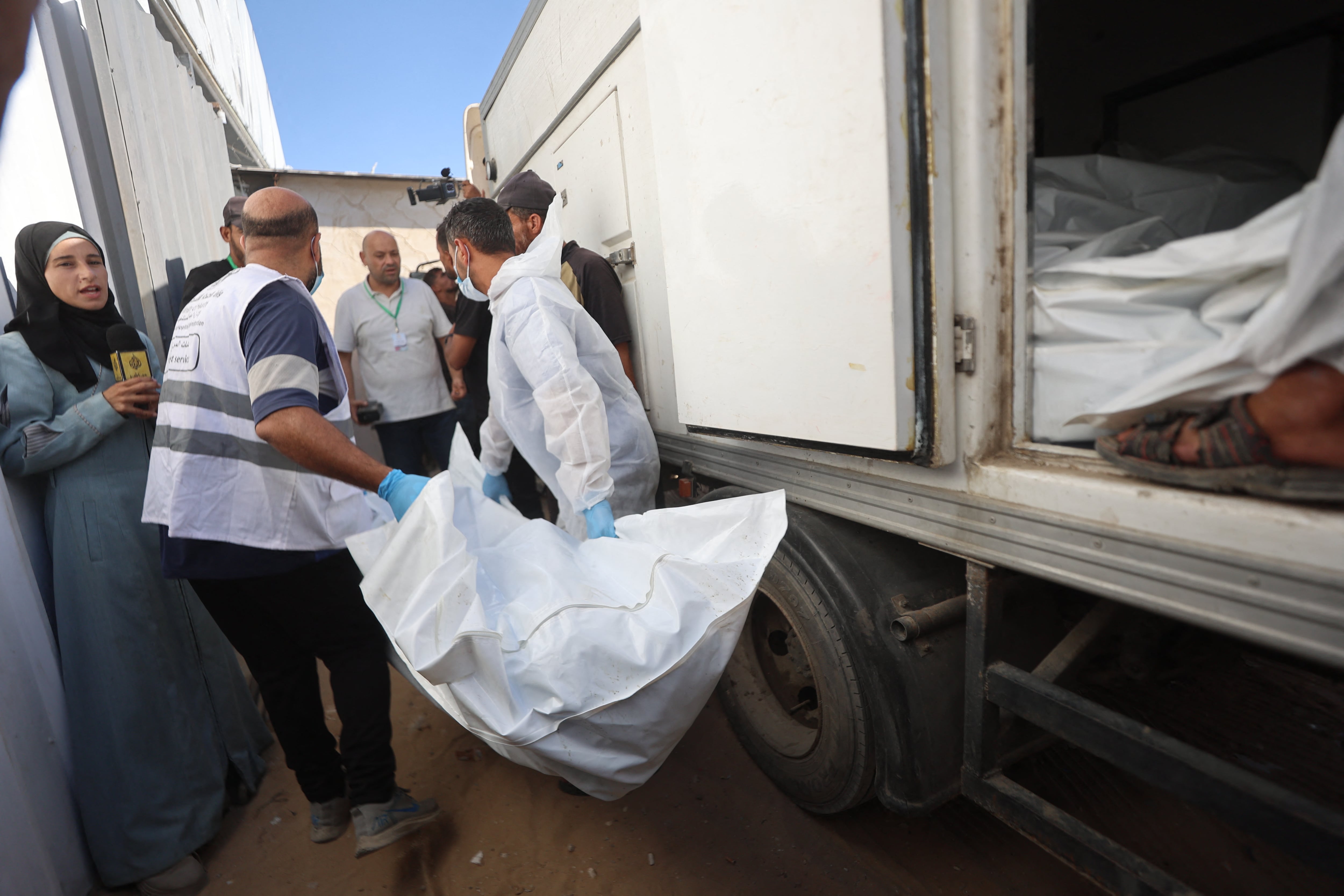 Forenses israelíes trasladan restos de palestinos como parte del canje con Hamas.